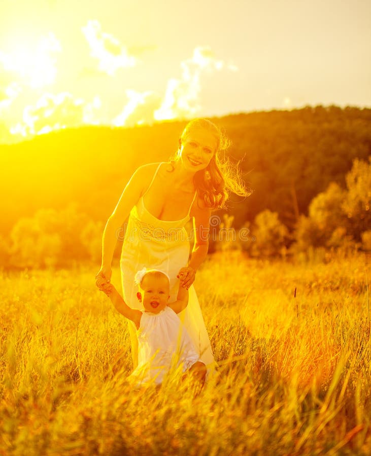 Happy family on nature mother and baby at sunset