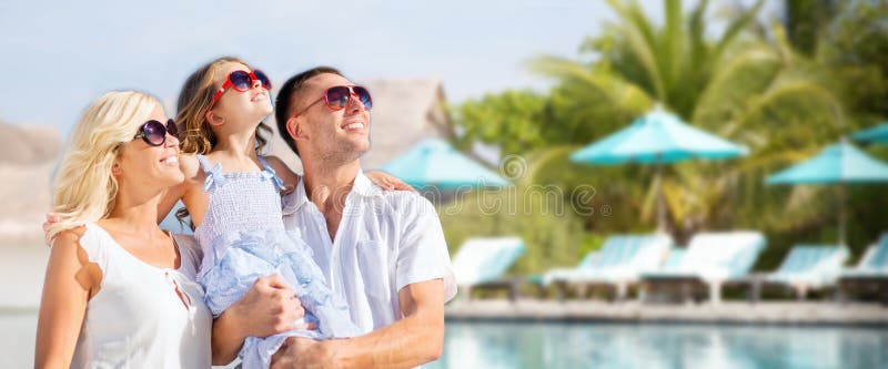 Happy family over hotel resort swimming pool