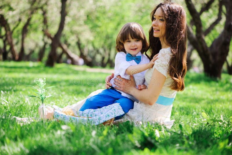 Happy family on picnic for mothers day. Mom and toddler son eating sweets outdoor in spring or summer royalty free stock photo Happy family on picnic for mothers day. Mom and toddler son eating sweets outdoor in spring or summer royalty free stock photo
