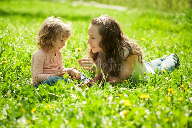 Happy family playing on green frass in spring park