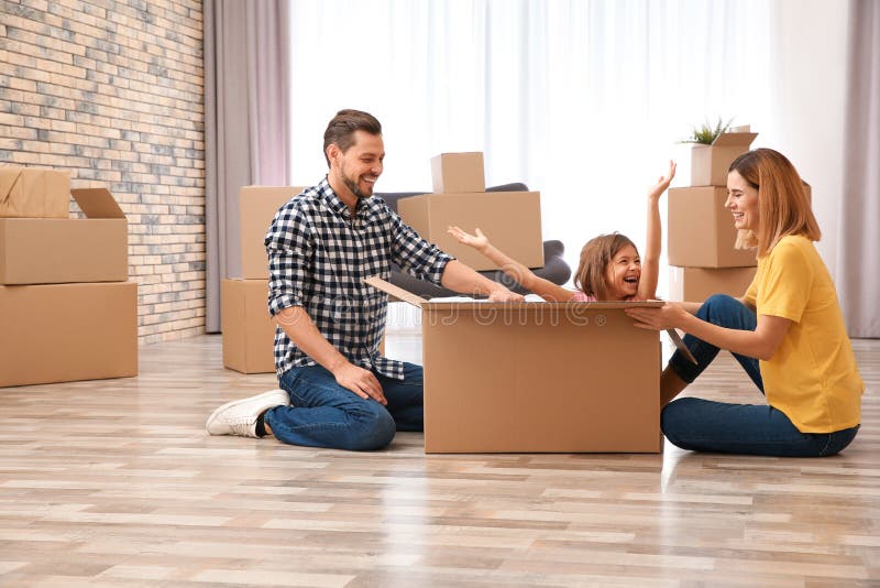 Happy family playing with cardboard box in their house. Moving day