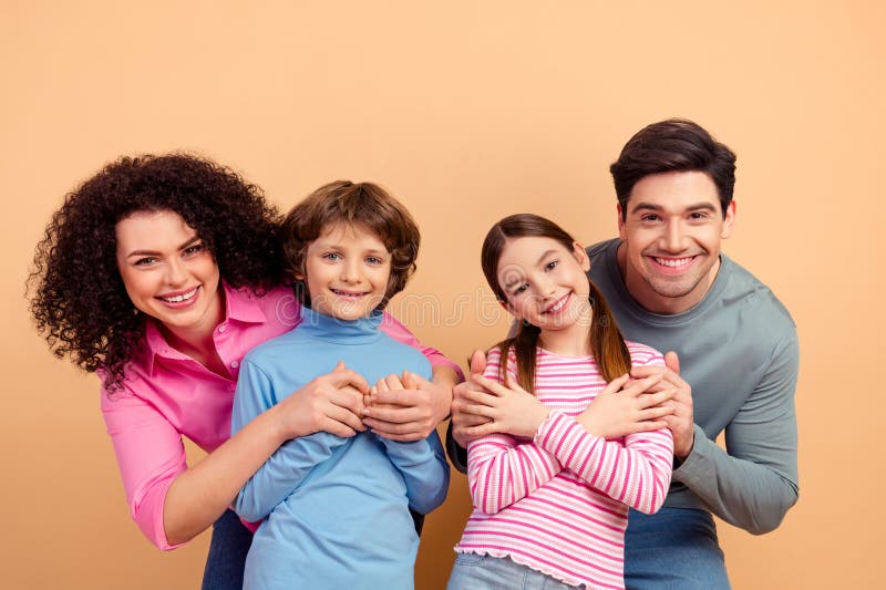 Happy family portrait with parents and children bonding together in a cheerful and relaxed atmosphere against a beige royalty free stock photography