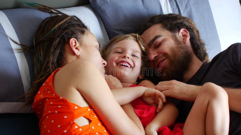 Happy Family Resting on the Bed. Mom Dad and Daughter Laugh and Chat Stock Footage - Video of little, couple: 171758488