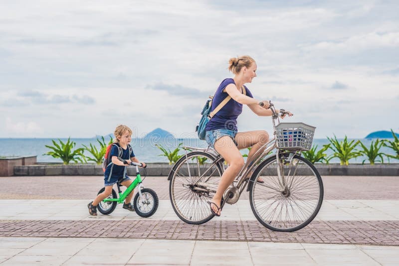 Happy family is riding bikes outdoors and smiling. Mom on a bike stock photos Happy family is riding bikes outdoors and smiling. Mom on a bike stock photos