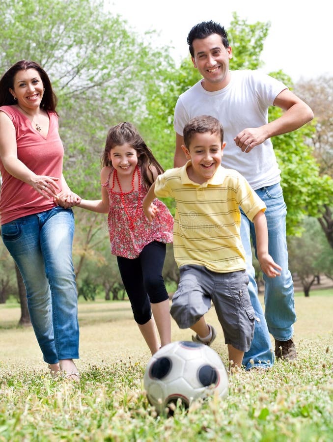 Famiglia felice correre sul palla da calcio, esterno.