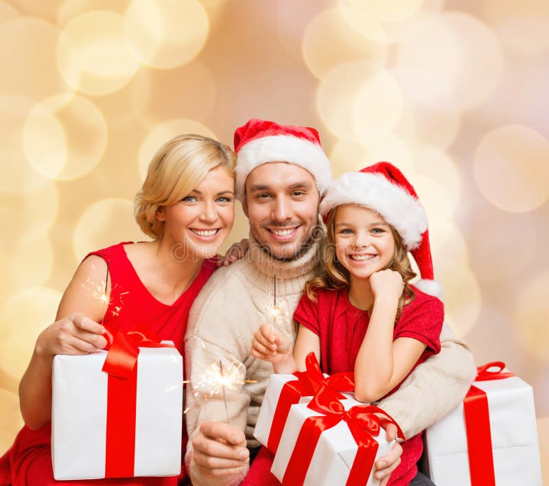 Happy family in santa helper hats with gift boxes