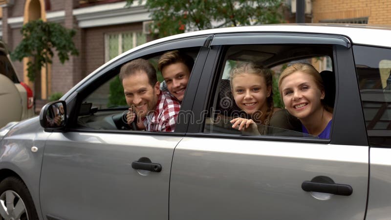 Happy family sitting in car and smiling into camera, automobile buying service, stock photo