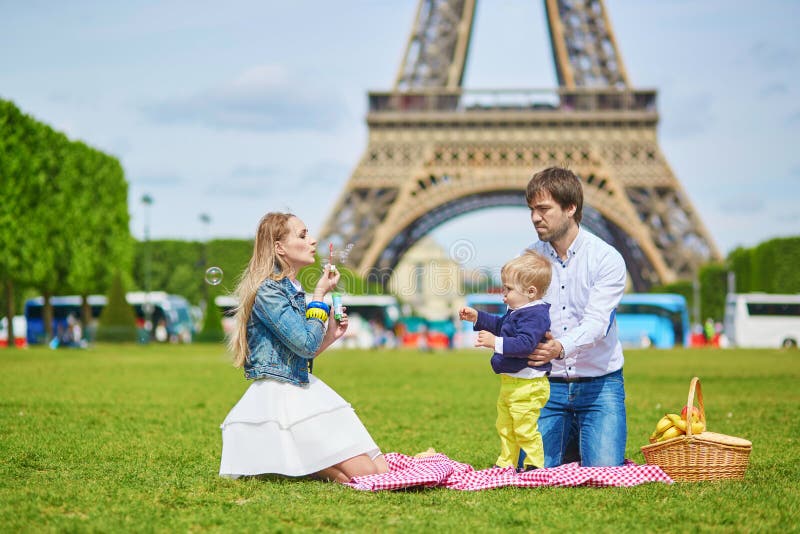 Happy family of three having picnic in Paris