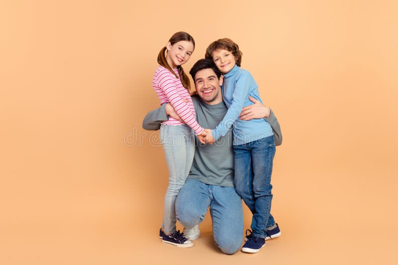 Happy family of three posing together, featuring a father with his son and daughter, expressing love and bonding royalty free stock photography