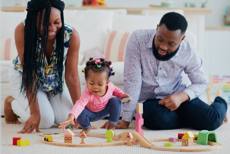 Happy family with toddler baby playing toy railway together at home royalty free stock photo