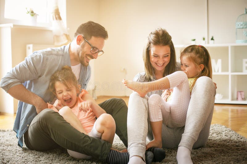 Happy family with two daughters playing at home. stock photography