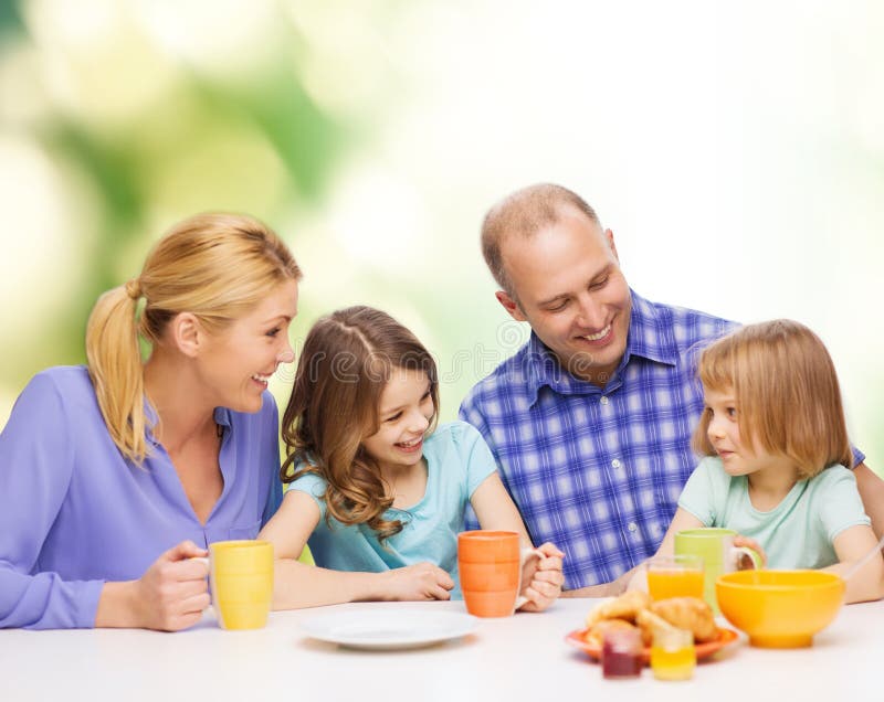 Happy family with two kids with having breakfast