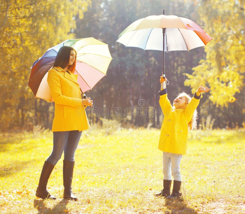 Happy family with umbrellas in sunny autumn rainy day stock images Happy family with umbrellas in sunny autumn rainy day stock images