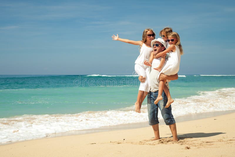 Happy family walking on the beach