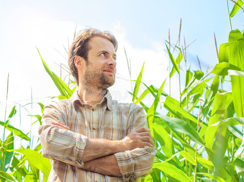 Happy farmer in front of his corn field