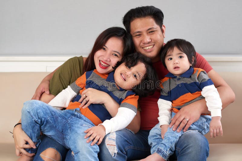 Happy Filipino men hugging his wife and two children. Happy Filipino men hugging his wife and two children