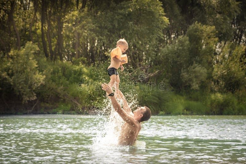 Happy father playing son kid throw up swimming lifestyle portrait concept happy paternity and childhood during summer countryside