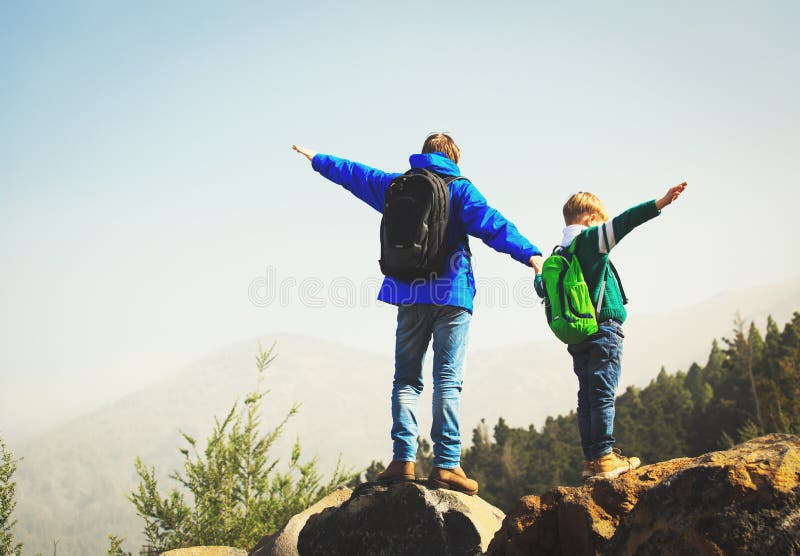 Happy father and son hiking climbing in mountains stock image