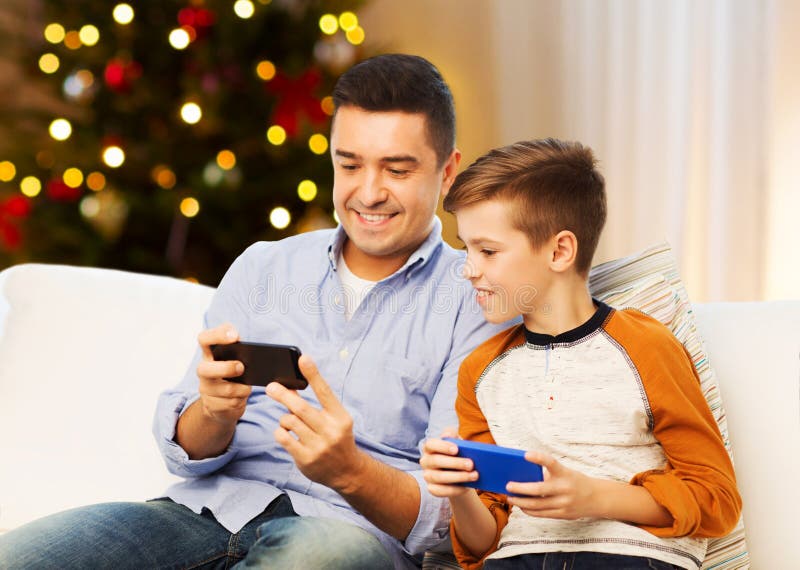Happy father and son with smartphones on christmas royalty free stock image Happy father and son with smartphones on christmas royalty free stock image