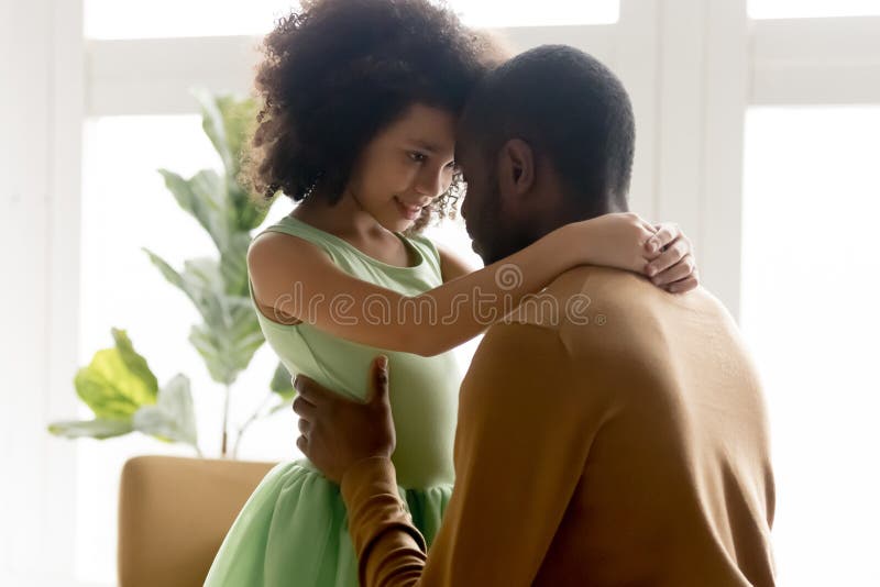 Mixed race little adorable daughter embrace loving father