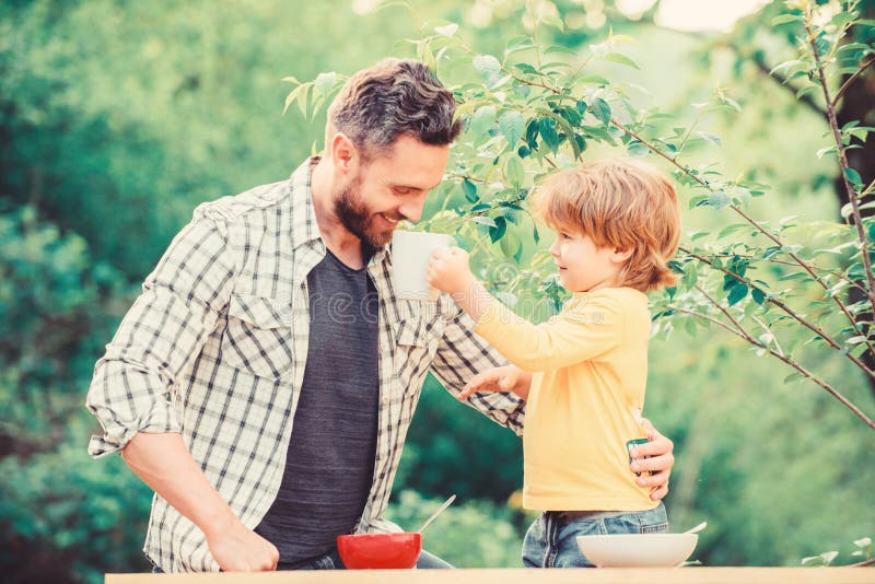 Happy fathers day. Little boy with dad have breakfast. son and father eating milk porridge. childhood happiness. Baby stock photo Happy fathers day. Little boy with dad have breakfast. son and father eating milk porridge. childhood happiness. Baby stock photo