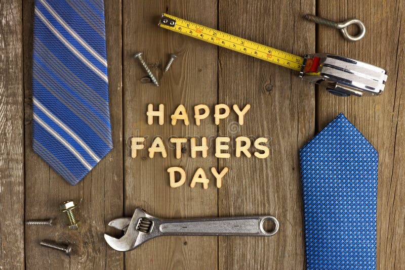 Happy Fathers Day wooden letters on a rustic wood background with tools and ties frame. Happy Fathers Day wooden letters on a rustic wood background with tools and ties frame