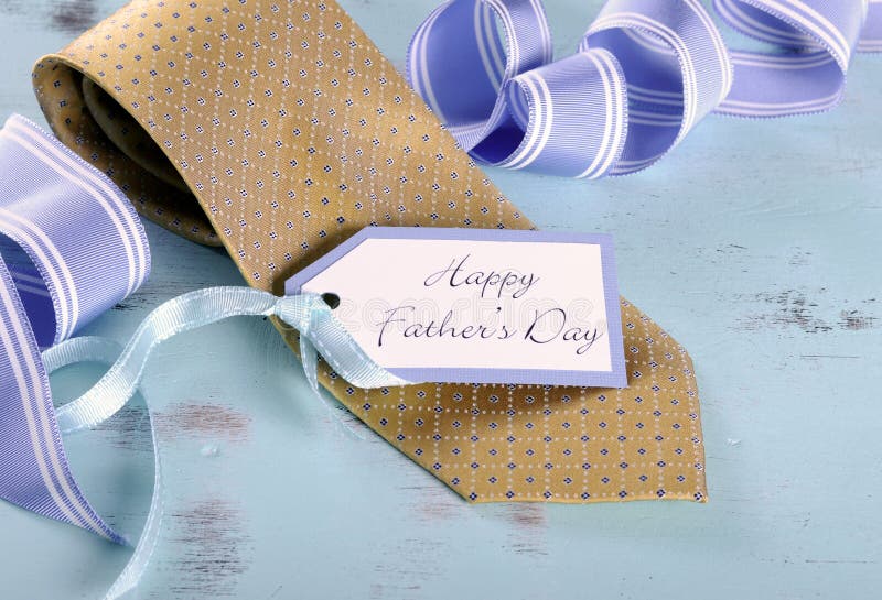 Happy Fathers Day yellow tie with gift tag on vintage aqua blue rustic shabby chic table