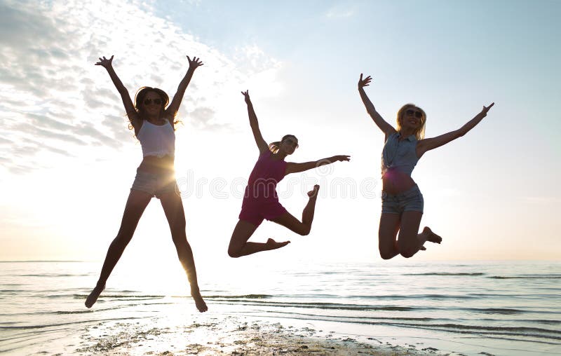 Happy female friends dancing and jumping on beach royalty free stock image Happy female friends dancing and jumping on beach royalty free stock image