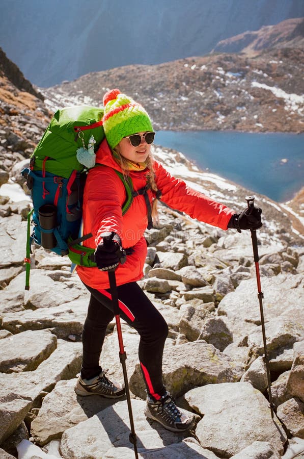 Happy female hiker on mountain top enjoys Popradske pleso