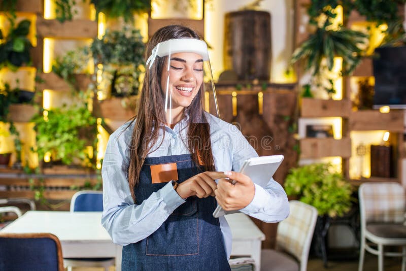 Female Waitress Wearing Face Shield, Visor Serves the Coffee in