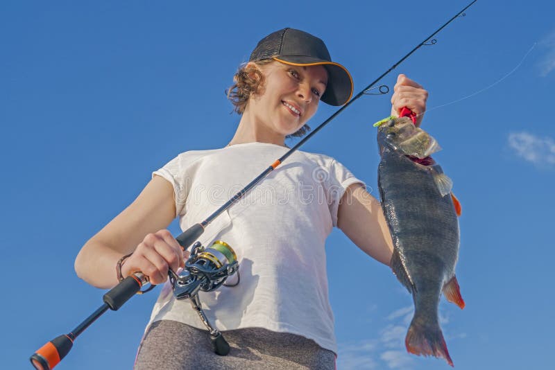 Happy fisher girl with perch fish trophy at the boat royalty free stock image Happy fisher girl with perch fish trophy at the boat royalty free stock image