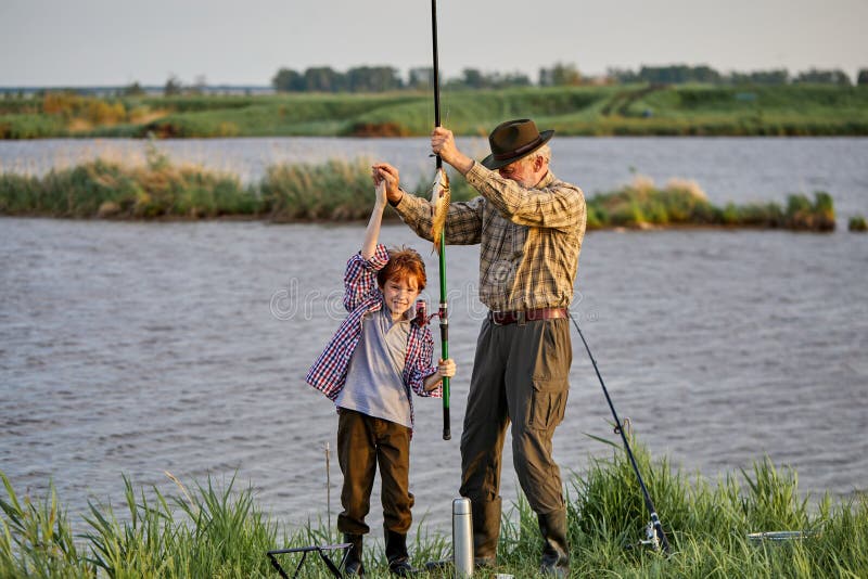 Happy Fisherman with Grandson Hold Caught Fish.Success Fishing at Wild Lake  Stock Photo - Image of together, caucasian: 226450958