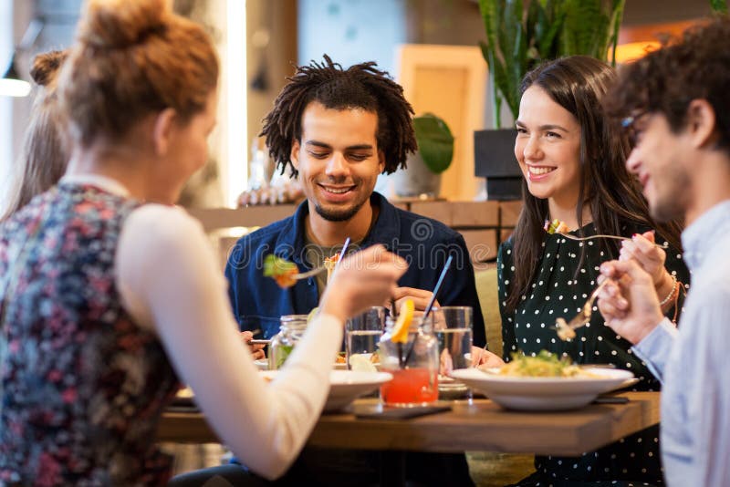 Happy friends eating at restaurant stock photography Happy friends eating at restaurant stock photography