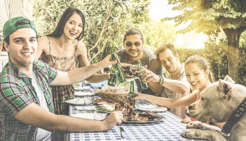 Happy friends having fun eating and toasting together at bbq royalty free stock image Happy friends having fun eating and toasting together at bbq royalty free stock image