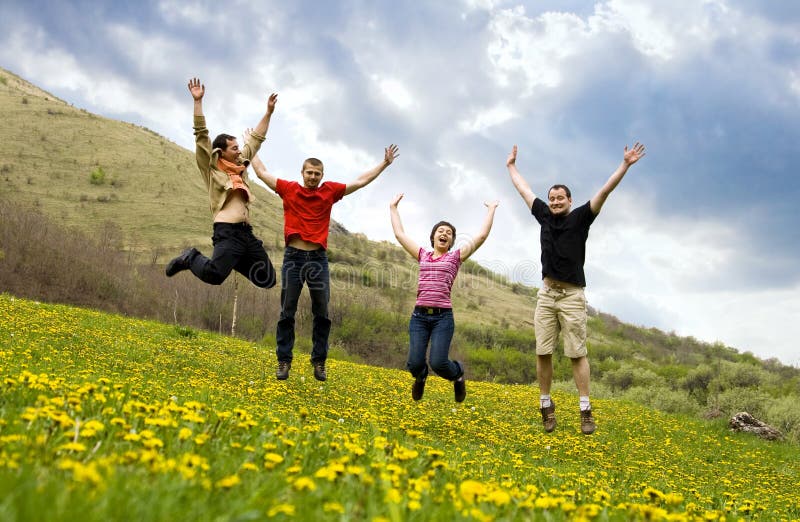 Happy friends jumping in meadow