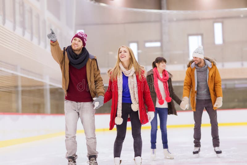 Happy friends pointing finger on skating rink royalty free stock image Happy friends pointing finger on skating rink royalty free stock image