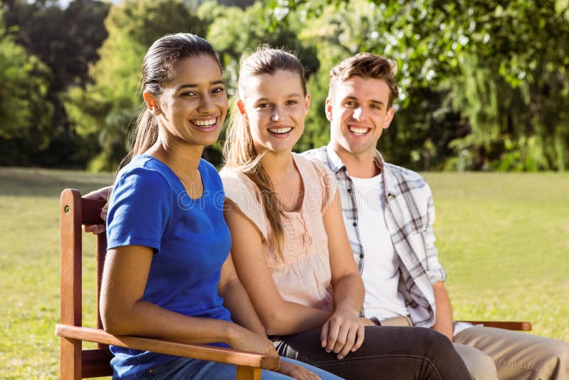 Happy friends sitting on bench stock image