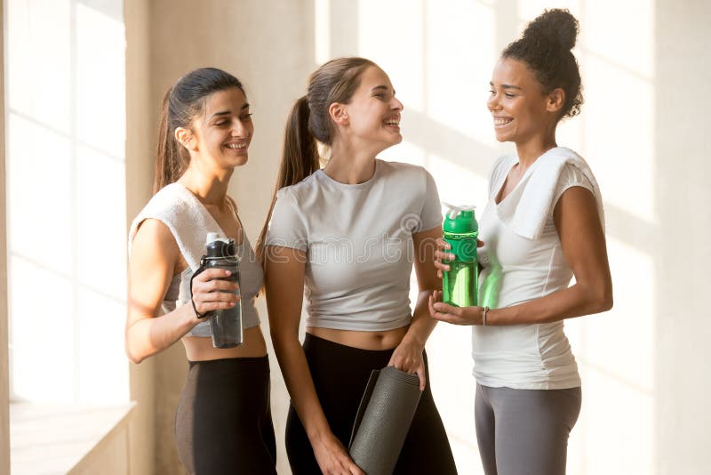 Happy friends talking after yoga session at gym royalty free stock photo Happy friends talking after yoga session at gym royalty free stock photo