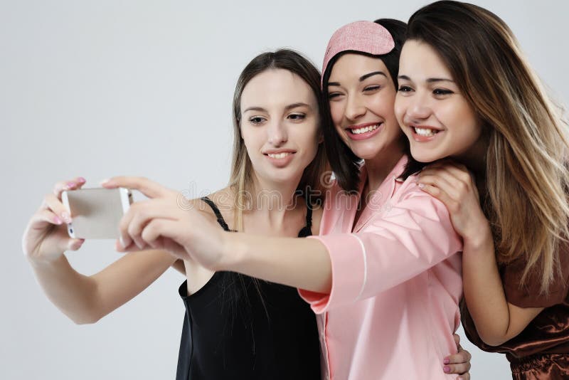 Happy Friends or Teenage Girls Wearing Pajamas with Smartphone Taking ...