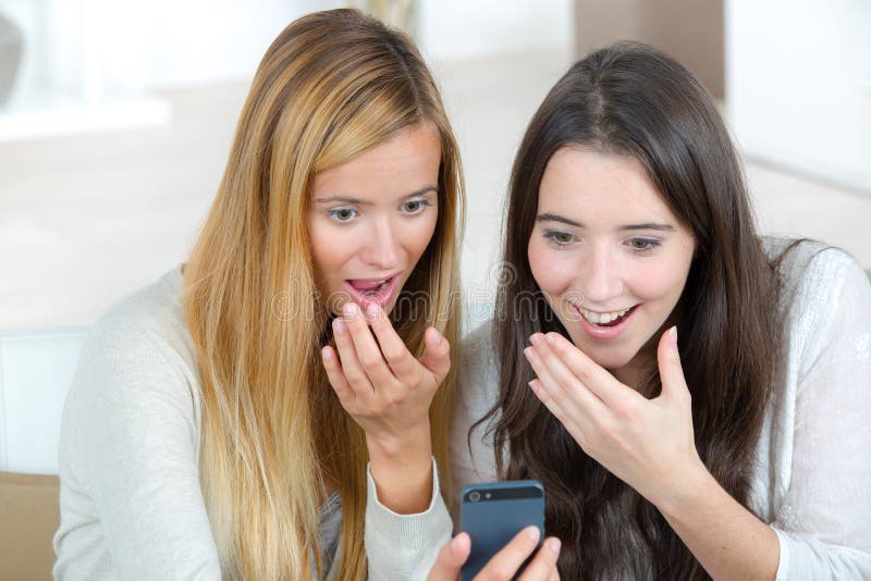 Happy friends using mobile phone royalty free stock image