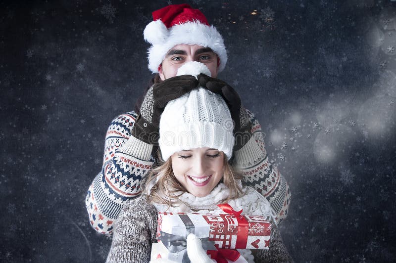 Happy funny couple covering snow background.