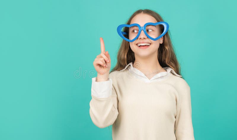 happy funny kid in glamour eyeglasses on blue background. funky teen girl having fun.