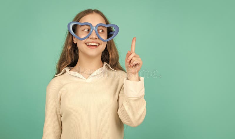 happy funny kid in glamour eyeglasses on blue background. funky teen girl having fun.