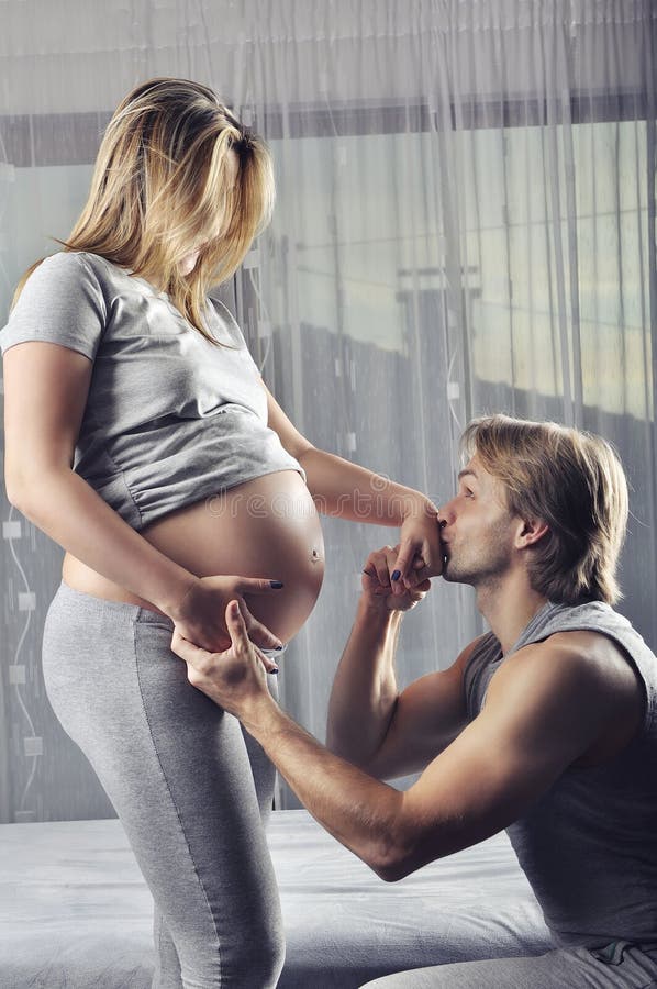 Happy future daddy kissing his pregnant wife’s hand