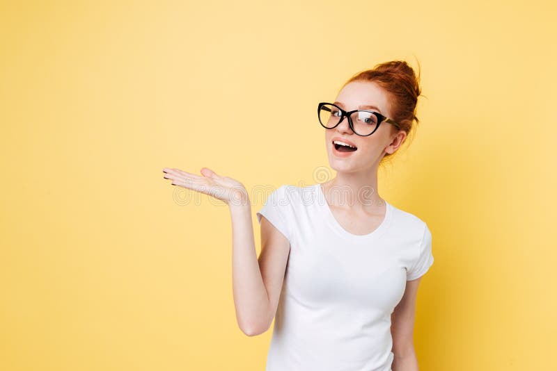 Happy ginger woman in eyeglasses holding invisible copyspace on pound royalty free stock images Happy ginger woman in eyeglasses holding invisible copyspace on pound royalty free stock images