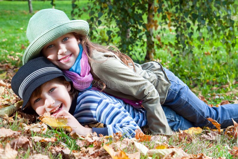 Happy girl and boy enjoying golden autumn