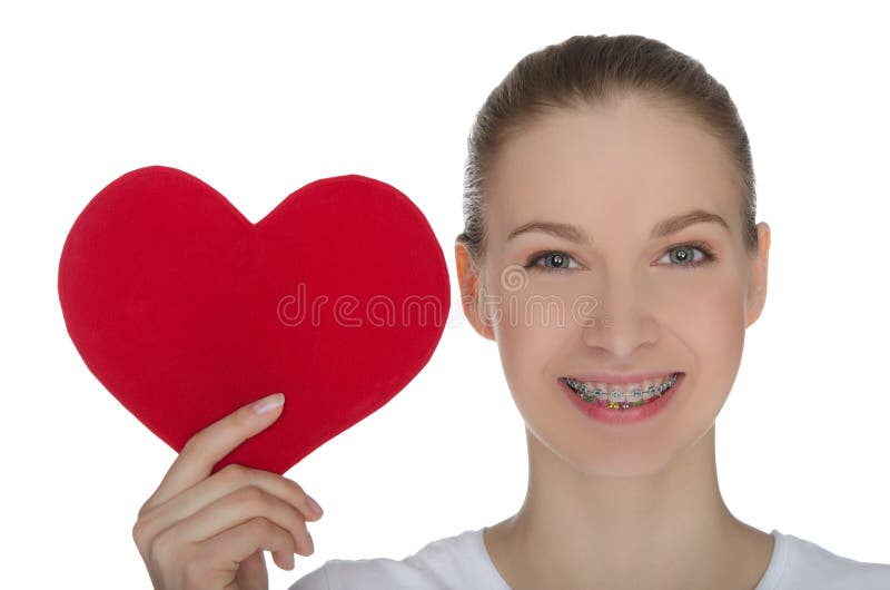 Happy girl with braces on teeth and red heart