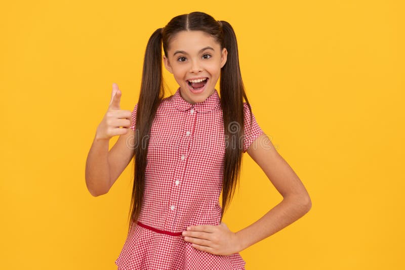 Happy girl child point finger gun hand gesture yellow background, pointing royalty free stock photography