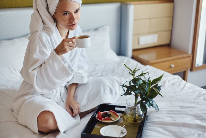 Happy Girl with a Cup of Coffee. Home Style Relaxation Woman Wearing Bathrobe and Towel after Shower. Spa Good Morning