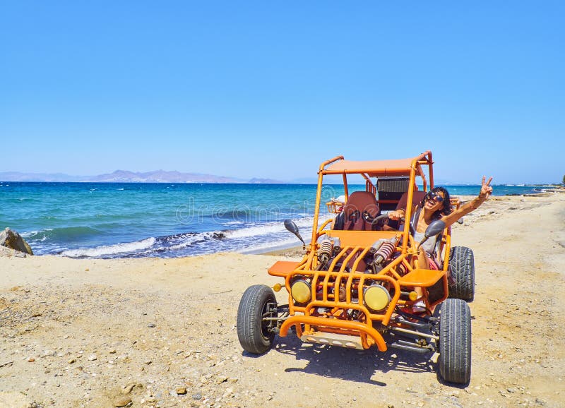 A happy girl driving a Buggy on a beach dune. Kos island. South royalty free stock photo A happy girl driving a Buggy on a beach dune. Kos island. South royalty free stock photo